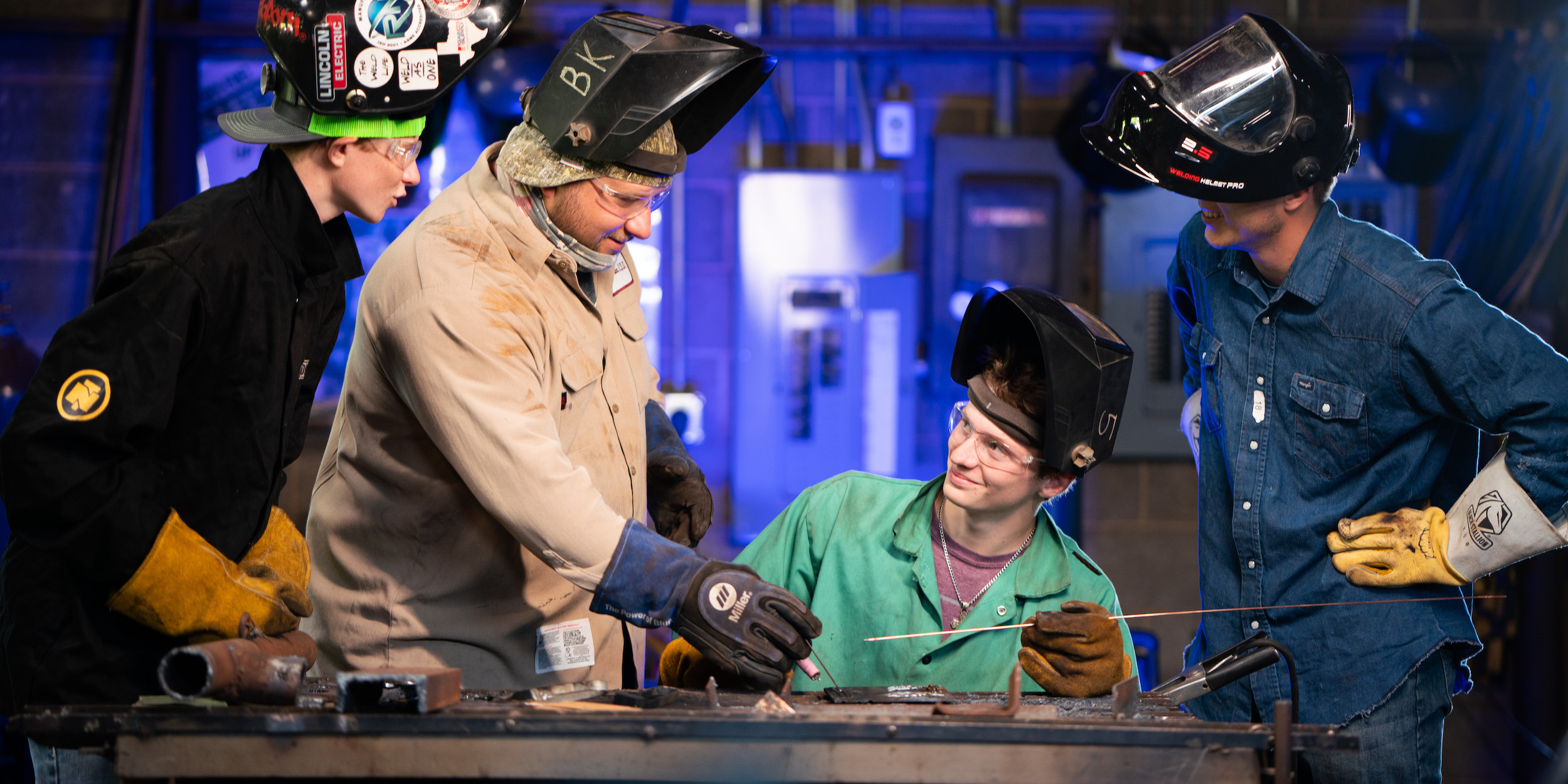 A teacher showing students how to weld